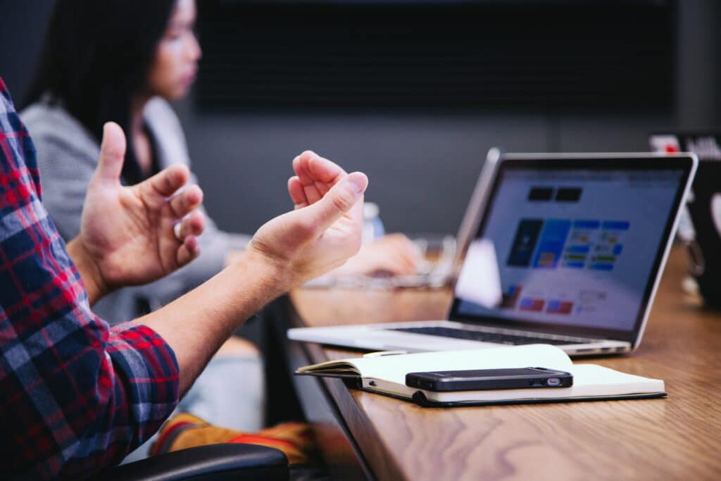 Image of person sitting at desk with laptop in blog: Finding the balance between marketing, creativity and law when creating a brand