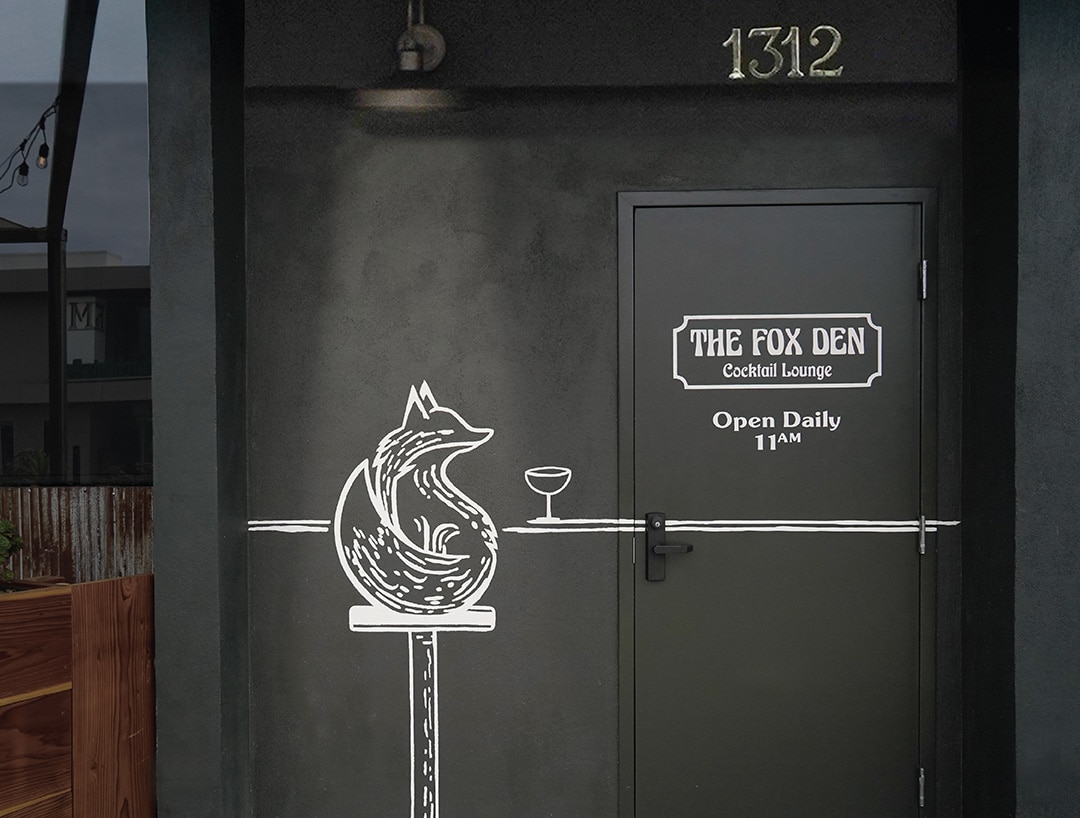 Entrance to The Fox Den cocktail bar in Redondo Beach featuring a custom mural of a fox with a martini, a memorable piece of their hospitality branding designed by Stellen Design.